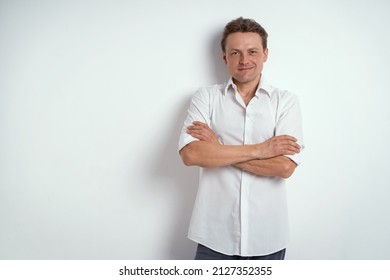 Looking Out Of Orange Notebook Or Journal Young Man In Eye Glasses Wearing White Shirt Isolated On White Background Or In The Office. Portrait Of A Shy Young Businessman Holding His Diary. 