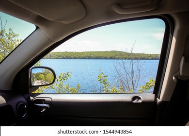 Looking out the passenger side window of a car at the Diamond Hill Reservoir in Cumberland, Rhode Island on a sunny summer day.