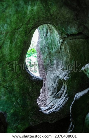 Looking out through the interesting natural stone doorway of Druid's Cave at Blarney Castle in Ireland