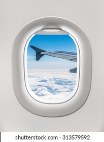 Looking Out The Window Of A Plane To The Aircraft Wing, Blue Sky And Clouds