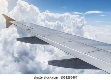 Looking out the window of plane.  View wing from the inside on sky and cloudy background