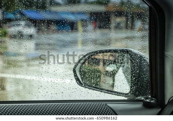 The Looking out the window. See the car\'s rearview\
mirrors when it rains.