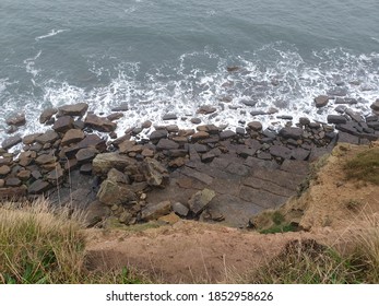 Looking Over A Cliff Edge To The Rocks And Sea Below.