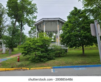 Looking At A Public Park In Nova Scotia. There Is A Handicap Parking Spot In Front And A Tall, Beautiful Gazebo For People To Lounge In. There Are Monuments And Fire Hydrants As Well.