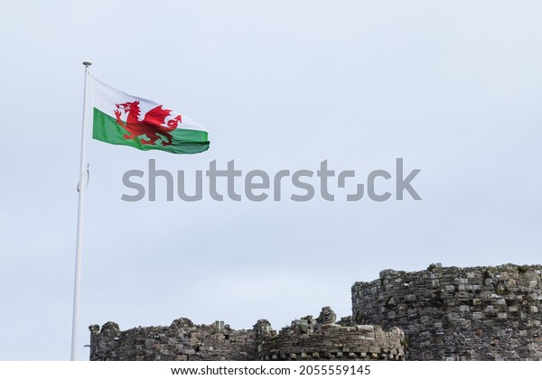 Looking up at the red dragon\
the Welsh flag seen above Beaumaris Castle in Wales during October\
2021.