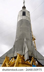 Looking Up at a Silver Colored Rocket on a Yellow Launch Stand
