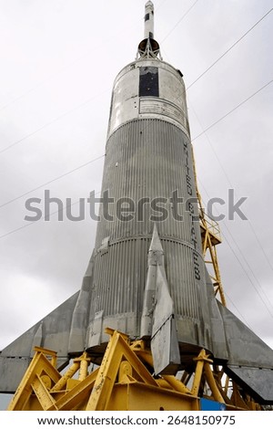 Looking Up at a Silver Colored Rocket on a Yellow Launch Stand