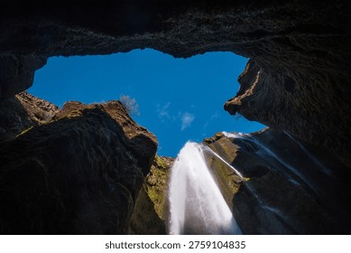 Looking up at sky at Gljufrabui cave waterfall Iceland