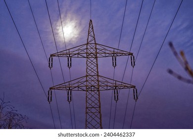 Looking up in the sky with moon and pylon with cables of power line at Swiss City of Zürich on a cloudy winter night. Photo taken December 23rd, 2023, Zurich, Switzerland. - Powered by Shutterstock