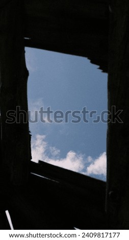 Looking skyward through the remnants of a ruined structure, this image is a portal to the past, where stories and histories linger in the open air, framed by remnants of what once was.