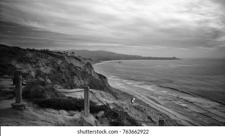 Looking South Towards San Diego From Torrey Pines Cliff. A Surfer Walks Towards The Beach As The Waves Crash Into The Coast.