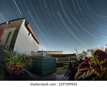 Looking At Star Trails From A City Rooftop Garden