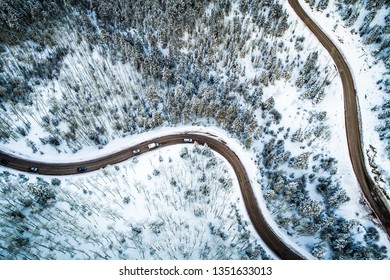 Looking Straight Down Over Snow Covered Landscape Forest And Curvy Windy Road Cutting Though The Mountains Aerial Drone View In Santa Fe , New Mexico