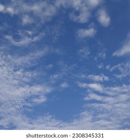 Looking straight up at the the sky. Thin clouds pattern with blue sky as background. 