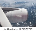 Looking through the Airplane Window with clouds, sky and mainland as seen through window of an aircraft during travel from Kuala Lumpur, Malaysia to Padang, Indonesia.