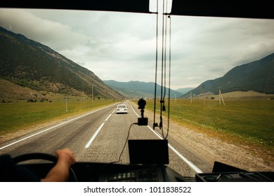 Looking Through Car Windscreen With Green Mountains Road. View Inside Out.