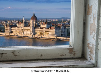 Looking through a castle window, the view of Buda in the foreground with the Hungarian Parliament building on the Pest side of Budapest in the background.