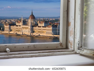 Looking through a castle window, the view of Buda in the foreground with the Hungarian Parliament building on the Pest side of Budapest in the background.