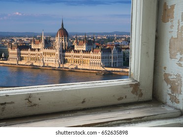 Looking through a castle window, the view of Buda in the foreground with the Hungarian Parliament building on the Pest side of Budapest in the background.