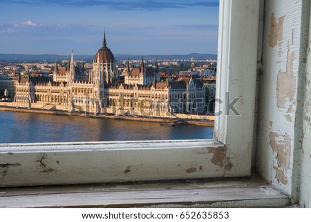Looking through a castle window, the view of Buda in the foreground with the Hungarian Parliament building on the Pest side of Budapest in the background.