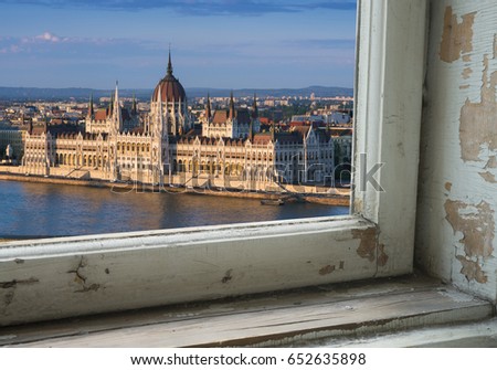 Looking through a castle window, the view of Buda in the foreground with the Hungarian Parliament building on the Pest side of Budapest in the background.