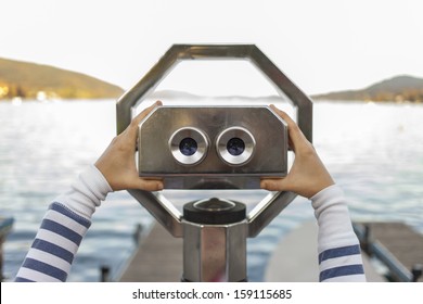 Looking through a coin operated binoculars, rear view