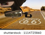 Looking through a dashcam car camera installed on a windshield with view of the Historic Route 66, with pavement sign in California, USA