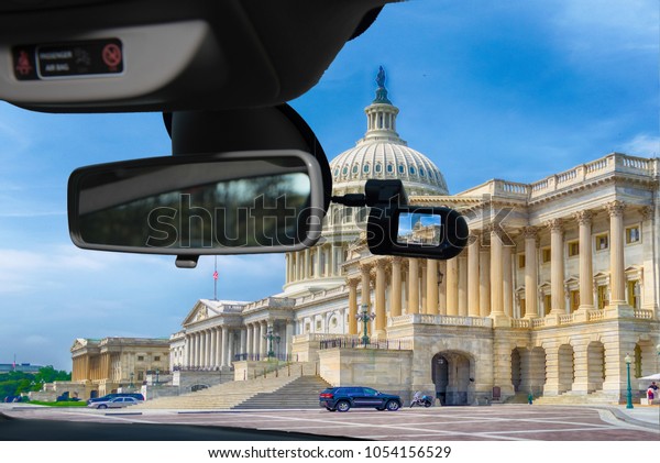Looking through a dashcam\
car camera installed on a windshield with view of United States\
Capitol building, iconic home of the United States Congress,\
Washington DC, USA
