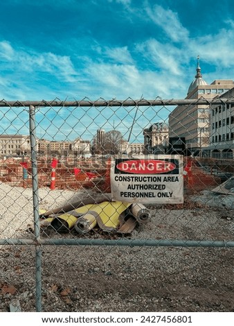 Looking through a fence to a major construction site at the Illinois State Capitol Complex. Sign reads, 
