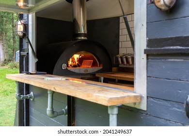 Looking Through A Hatch Of A Mobile Catering Van With A Pizza Oven Burning Inside