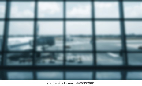 Looking through a large grid window at an airplane parked on the airport tarmac on a cloudy day.