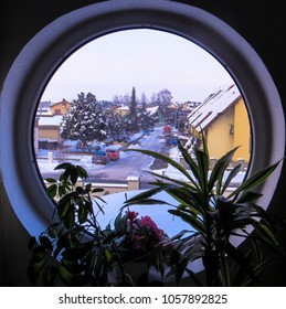 Looking through small round window through to cute snowy town