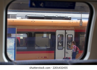 Looking Through Train Window To Senior Woman With Backpack And Mobile Phone At Zürich Main Railway Station On A Late Summer Day. Photo Taken September 5th, 2022, Zurich, Switzerland.