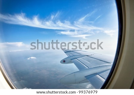 Looking through window aircraft during flight in wing with a nice blue sky
