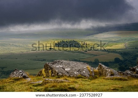 looking from the top of sheep's tor in a national park in the early morning , greeted with moody clouds and sunlight hitting the copse of trees Stock fotó © 