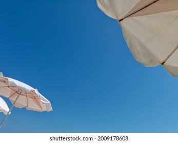 Looking Upward At Sky With Beach Umbrellas Overhead.