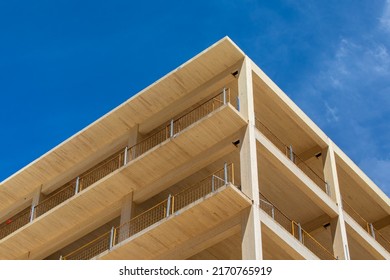 Looking up at the vertical supports, balconies and interior ceiling of a engineered timber multi story green, sustainable residential high rise apartment building construction project - Shutterstock ID 2170765919