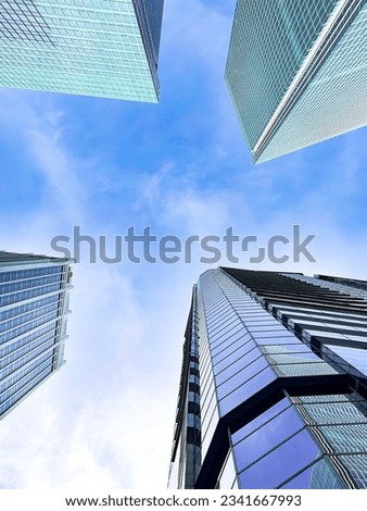 looking up view of panoramic modern city skyline with blue sky 