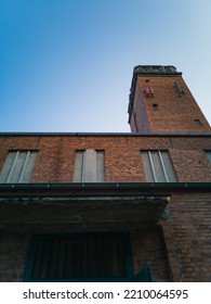 Looking up to wall and tower of old red brick church at sunny day