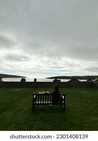Looking at the water while siting on a bench