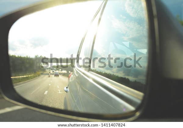 Looking in the\
wing mirror whilst driving in a\
car