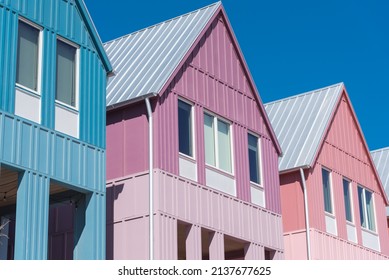 Lookup view of metal roof and gutter on row of new development colorful house with clear blue sky background.  Close-up facade of two story townhomes near Wheeler District, Oklahoma City, USA