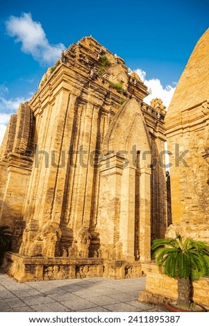 Lookup up view of North Tower or Thap Chinh and Central Tower or Thap Nam of Ponagar Cham Towers with terraced pyramidal roof, built partly of recycled bricks, sunny blue cloud sky. Nha Trang, Vietnam