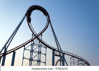 Loop of a scaring roller coaster back lit by the sunset.