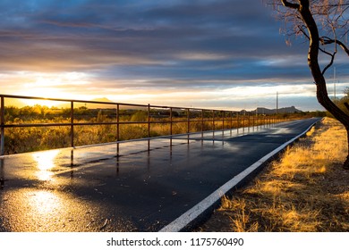 The Loop In Tucson, Arizona. A Walking, Running And Biking Path. A Beautiful Sunset With Wet Pavement Picking Up The Light And Reflecting It. The Railing Disappears In The Distance, Nice Lines. 2018