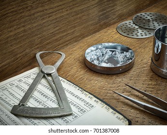 Loose Diamonds, Diamond Sieves and Diamond Measurement Gauge Shown on Dark Natural Wood Background with Antique Book.  - Shutterstock ID 701387008