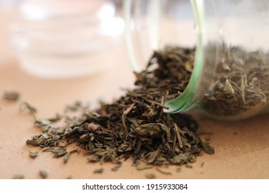 Loose Green Tea Scattered From A Glass Jar