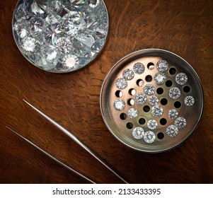 Loose Polished Round Diamonds in Sieve on Dark Wood Background - Shutterstock ID 2133433395