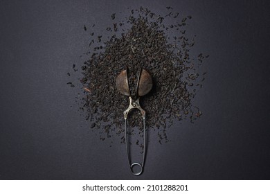 Loose Tea On A Black Background. Loose Tea In An Old Brewing Sieve. The Concept Of Loose Tea And Tea Drinks.