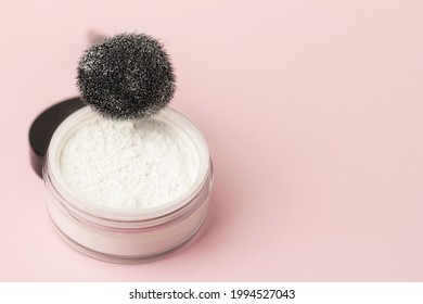 Loose white face powder with black brush. Professional cosmetics.